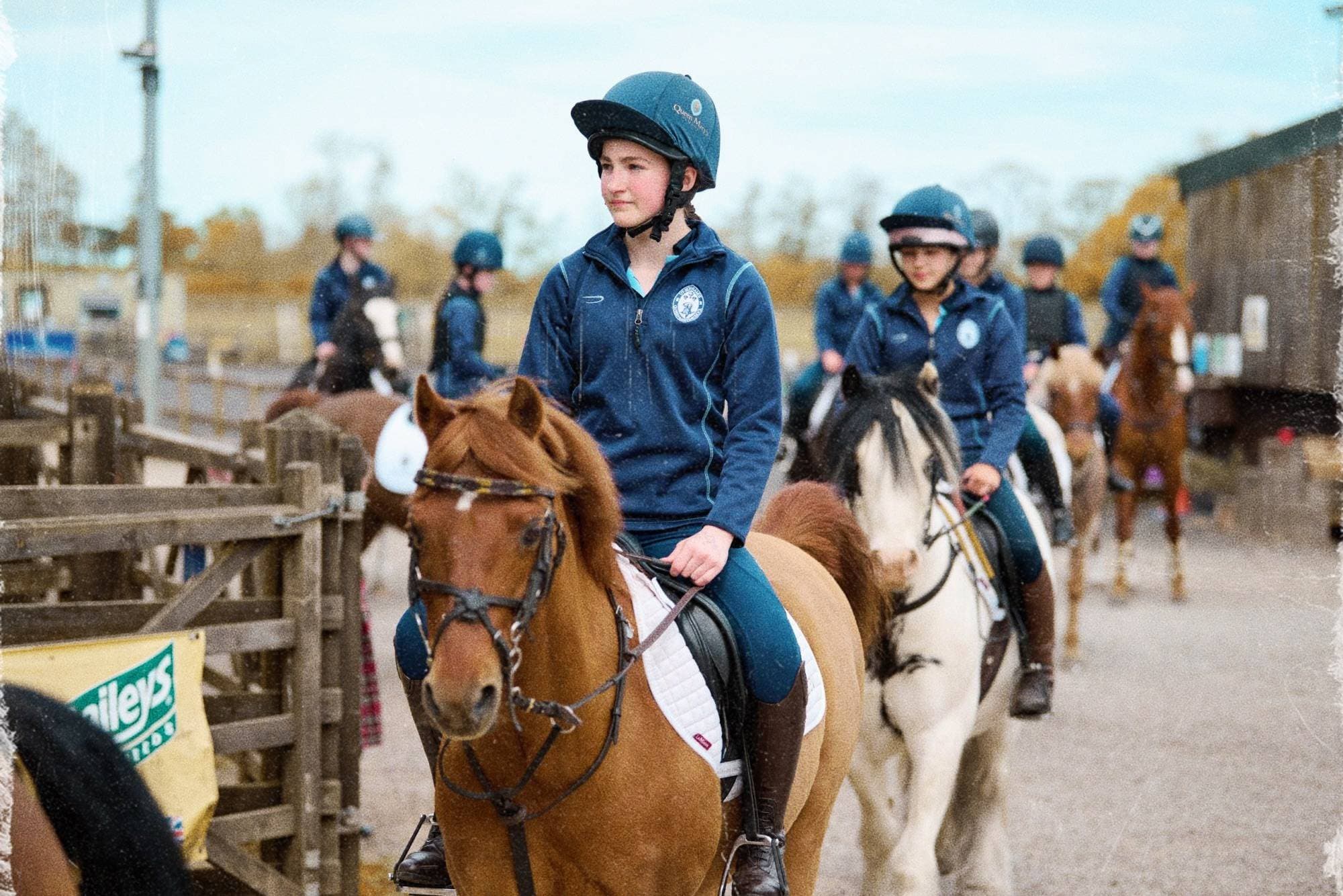 Horses and riders at a countryside stable